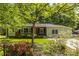 Charming home featuring a landscaped front yard with beautiful flowers and a classic brick and siding exterior at 1740 Fairbanks Sw St, Atlanta, GA 30310