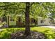 A quaint residence nestled behind a mature tree, showcasing a well-maintained lawn and inviting curb appeal at 1740 Fairbanks Sw St, Atlanta, GA 30310