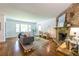 Open living room featuring a stone fireplace, hardwood floors, comfortable seating, and ample natural light at 1740 Fairbanks Sw St, Atlanta, GA 30310