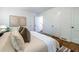 Inviting main bedroom featuring hardwood floors, white walls, a sitting bench, and natural light at 1740 Fairbanks Sw St, Atlanta, GA 30310