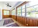 Bright sunroom with wood-paneled walls, tiled floor, and lots of natural light from large windows at 1740 Fairbanks Sw St, Atlanta, GA 30310