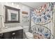 Stylish bathroom with a framed mirror, marble countertops, and unique shower curtain at 2789 Townley Cir, Atlanta, GA 30340