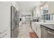 Bright kitchen boasts stainless steel appliances, white cabinetry, long counters, and access to the backyard at 2789 Townley Cir, Atlanta, GA 30340
