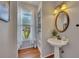 Charming powder room with pedestal sink, decorative mirror, and window with natural light at 5108 Staplehurst Ln, Woodstock, GA 30189