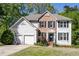 Charming two-story home with a brick facade, black shutters, and a well-maintained front yard at 5108 Staplehurst Ln, Woodstock, GA 30189