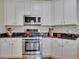 Bright kitchen featuring white cabinets, stainless steel appliances, and dark granite countertops at 5108 Staplehurst Ln, Woodstock, GA 30189