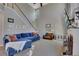Spacious living room featuring a cozy blue couch, tall ceilings, and brick fireplace at 5108 Staplehurst Ln, Woodstock, GA 30189