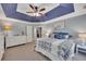 A spacious main bedroom features a tray ceiling, ceiling fan, and plush carpet flooring at 5108 Staplehurst Ln, Woodstock, GA 30189