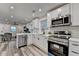 Open concept kitchen with breakfast bar, stainless appliances, and wood-look floors at 538 Center Hill Nw Ave, Atlanta, GA 30318