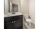 Bathroom featuring a dark vanity, ample countertop space, and a modern toilet at 6404 Brookside Se Blvd, Mableton, GA 30126