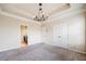 Carpeted main bedroom with decorative chandelier and easy access to the en-suite bathroom at 6404 Brookside Se Blvd, Mableton, GA 30126