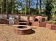 Outdoor cooking and entertainment area featuring a built-in grill, pizza oven, and a stone fire pit at 7027 Grinder Drive, Austell, GA 30168