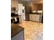 Bright kitchen with stainless steel refrigerator, granite countertops, and tiled floor at 7027 Grinder Drive, Austell, GA 30168