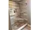 Corner shower featuring stylish tile and a built-in shelf at 7027 Grinder Drive, Austell, GA 30168