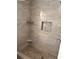 Walk-in shower with pebble floor and tile walls with a decorative inset shelf at 7027 Grinder Drive, Austell, GA 30168