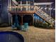 Relaxing backyard featuring a pool, patio seating, and string lights on the deck above at 2111 Harmony Dr, Canton, GA 30115