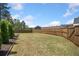 Large, fenced backyard with a lush lawn and mature trees, offering ample space for outdoor activities at 2111 Harmony Dr, Canton, GA 30115