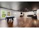 Expansive basement with a pool table, hardwood floors, dark ceiling, and cozy lounge area at 2111 Harmony Dr, Canton, GA 30115