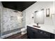 Bathroom featuring marble-style tile shower, vanity with sink, and modern lighting fixtures at 2111 Harmony Dr, Canton, GA 30115