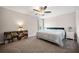Carpeted bedroom with a ceiling fan, neutral walls, large window and bookshelf with books at 2111 Harmony Dr, Canton, GA 30115