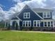 Charming two-story home with blue siding, white trim, and a well-manicured lawn under a bright blue partly cloudy sky at 2111 Harmony Dr, Canton, GA 30115