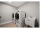 Modern laundry room featuring a washing machine, dryer, and utility sink at 2111 Harmony Dr, Canton, GA 30115