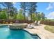 A beautiful waterfall feature and lounge chairs enhance the in-ground pool and stone patio at 2111 Harmony Dr, Canton, GA 30115
