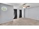 A spacious carpeted bedroom with natural light, a ceiling fan, and windows with dark curtains at 2998 Kenville Ln, Decatur, GA 30034