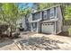 Charming two-story home with blue accents, attached garage, and mature trees surrounding the property at 2998 Kenville Ln, Decatur, GA 30034