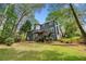Beautiful backyard of home featuring a large wooden deck, mature trees, and green lawn at 3522 Evans Ridge Trl, Atlanta, GA 30340