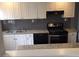 Clean kitchen with granite countertops, stainless steel appliances, and white cabinetry, enhanced by a gray backsplash at 60 Cleveland Se St, Atlanta, GA 30316
