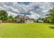 Grassy backyard with a deck, patio, and basketball court area surrounded by wooden fence at 981 Golden Meadows Ln, Loganville, GA 30052