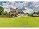 Wide backyard view of home showing a deck, covered patio, basketball court, and large lawn at 981 Golden Meadows Ln, Loganville, GA 30052