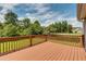 Open wooden deck area with brown railings overlooking the grassy yard and mature trees at 981 Golden Meadows Ln, Loganville, GA 30052