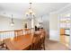 Dining room featuring wood table and chairs with view into the kitchen and living room at 981 Golden Meadows Ln, Loganville, GA 30052