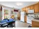 Cozy kitchen with wooden cabinets, white appliances, and a dining area at 981 Golden Meadows Ln, Loganville, GA 30052