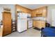Functional kitchen featuring wood cabinets, white appliances, and tile flooring at 981 Golden Meadows Ln, Loganville, GA 30052