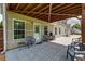 View of covered patio from backyard showing outdoor seating, grill and door into house at 981 Golden Meadows Ln, Loganville, GA 30052