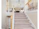 Carpeted staircase featuring natural wood railings and neutral decor at 981 Golden Meadows Ln, Loganville, GA 30052