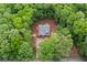 Aerial view of a house nestled among trees, featuring a dark roof, and a road nearby at 1687 Harmony Rd, Temple, GA 30179