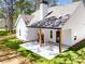 Rear of the house with a covered patio with a stone fireplace and nice green grass at 1687 Harmony Rd, Temple, GA 30179