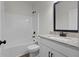 Well-lit bathroom featuring a shower-tub combo, granite countertop, and sleek black hardware at 1687 Harmony Rd, Temple, GA 30179