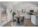 Open dining area with modern table set near white kitchen featuring stainless steel appliances and granite counters at 1687 Harmony Rd, Temple, GA 30179