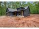 Contemporary gray home with wooden porch columns and attached garage on a spacious lot surrounded by trees at 1687 Harmony Rd, Temple, GA 30179