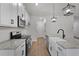 Bright kitchen featuring white cabinets, granite countertops, stainless steel appliances, and modern pendant lighting at 1687 Harmony Rd, Temple, GA 30179