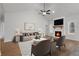 Bright living room showcasing vaulted ceilings, a ceiling fan, fireplace, large windows and modern furnishings at 1687 Harmony Rd, Temple, GA 30179