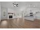 Open-concept living room featuring a fireplace, vaulted ceilings, modern lighting, and a view of the kitchen at 1687 Harmony Rd, Temple, GA 30179