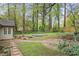 Landscaped backyard features a stone patio, mature trees and lush greenery at 172 Forest Nw Ln, Marietta, GA 30064