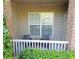 Cozy covered patio with white railing, chairs, and view of lush greenery at 1910 Cedar Glenn Way # 4104, Atlanta, GA 30339