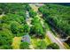 A high angle view of a landscaped home near a road and surrounded by tall green trees at 5950 Central Church Rd, Douglasville, GA 30135